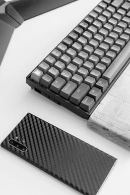 Phone next to mechanical keyboard above a table